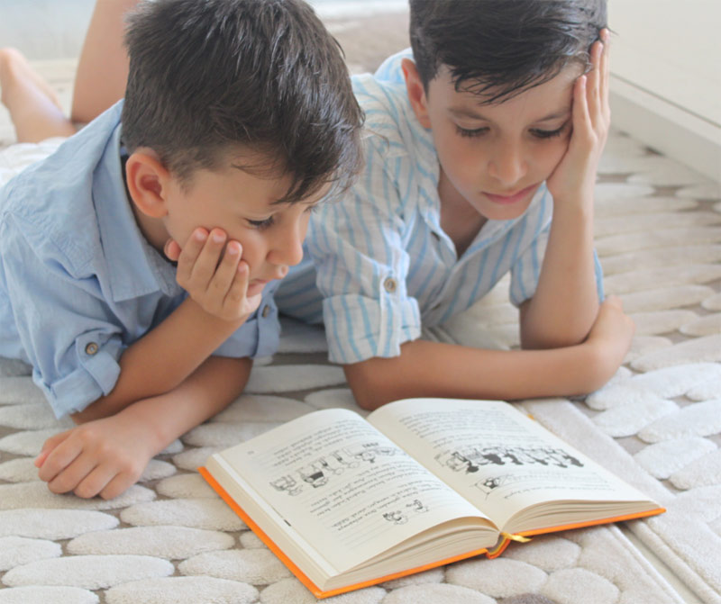 Two boys reading a book together