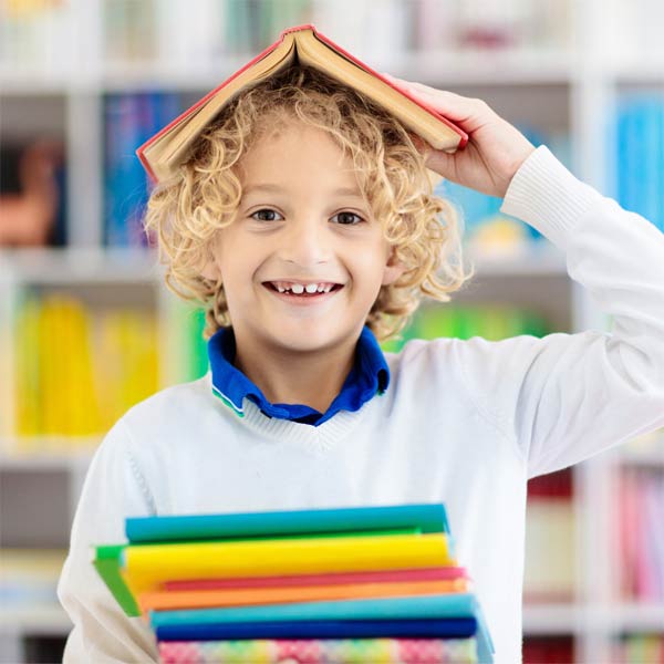 Smiling boy with colourful books